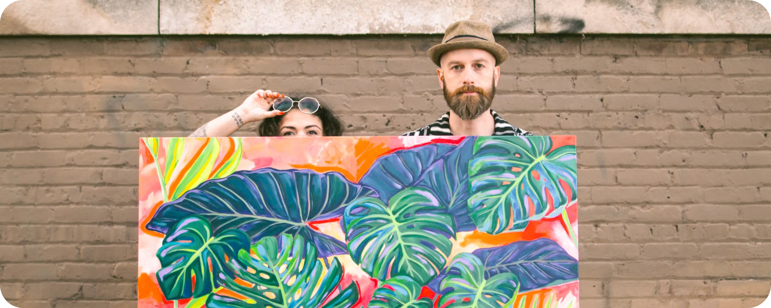 Reid and Claudia hold the tropical painting